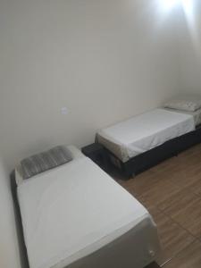 two beds sitting next to each other in a room at Pousada Joinville in Joinville