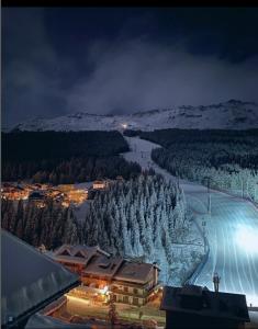 a view of a ski resort in the snow at night at Hotel Genzianella in Santa Caterina Valfurva