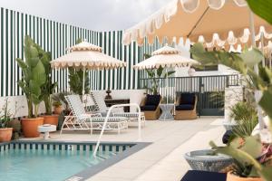 a patio with chairs and a pool with plants at Palihouse West Hollywood at Beverly Hills in Los Angeles