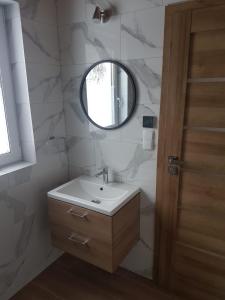 a bathroom with a sink and a mirror at Domek z widokiem in Istebna