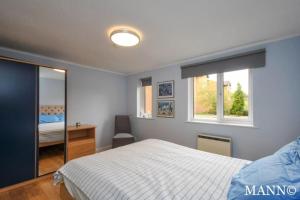 Un pat sau paturi într-o cameră la Morden flat close to DLR station with free parking