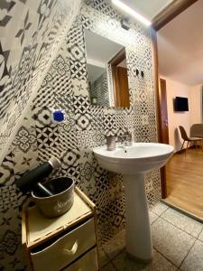 a bathroom with a sink and a mirror at Restaurant Pensiunea Carmen in Ranca