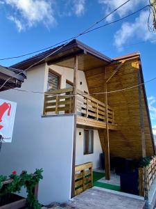 una casa con balcones de madera en un lateral en Restaurant Pensiunea Carmen, en Ranca
