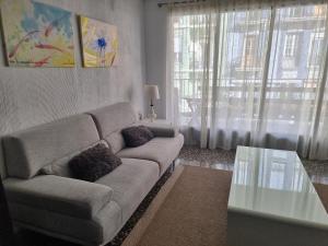 sala de estar con sofá y mesa de cristal en Apartamento Ruzafa en Valencia