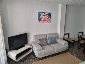 sala de estar con sofá y TV de pantalla plana en Apartamento Ruzafa, en Valencia