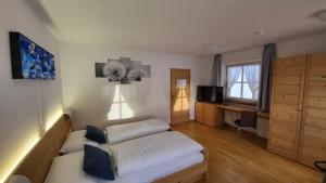 - un salon avec un lit et une télévision dans l'établissement Badl im Mühlbacher Talile, à Gais