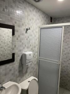 ein Bad mit einer Dusche, einem WC und einem Waschbecken in der Unterkunft Hotel Gloria Del Norte in Cartagena de Indias