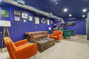 a living room with blue walls and leather furniture at Modern 4BR Pilsen Apt near Restaurants - Racine 202 in Chicago