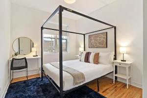een slaapkamer met een hemelbed en een spiegel bij Contemporary 4BR Apt close to Restaurants - Racine 202 in Chicago