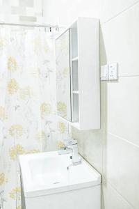 a white bathroom with a sink and a mirror at Beautiful home with private rooms in Pantang