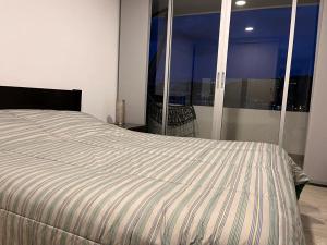 1 cama en un dormitorio con vistas a la ciudad en Increible vista al lago, en Paipa