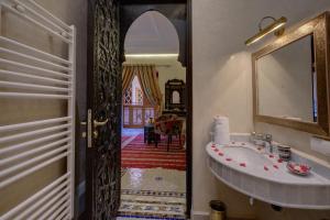 bagno con lavandino e specchio di Riad Diamond Of Marrakech a Marrakech