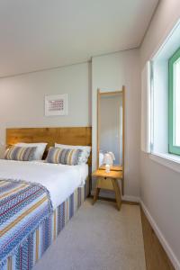 1 dormitorio con 2 camas y espejo en Boutique Rentals- SEA Breeze Apt en Oporto