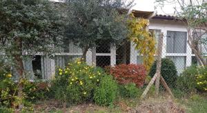 雷卡納蒂的住宿－La Casa di Tara B&B Armonia e Natura，前面有鲜花的白色房子