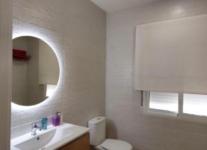 een badkamer met een toilet, een wastafel en een spiegel bij Villa Mateo in Murcia
