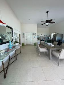 a living room with a table and a ceiling fan at Villa Bianca Bacalar in Bacalar