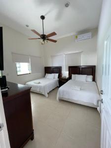 1 dormitorio con 2 camas y ventilador de techo en Villa Bianca Bacalar en Bacalar