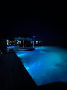 una piscina por la noche con luces azules en Villa Bianca Bacalar en Bacalar