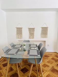 a dining room with a glass table and chairs at Maktub Europa - Hostal Boutique in Santiago