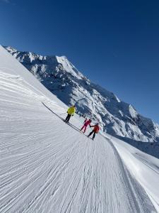 three people are skiing down a snow covered mountain at Hotel Genzianella in Santa Caterina Valfurva