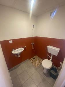 a bathroom with a toilet and a sink at Aeropark Residencial (B&B) in Maputo