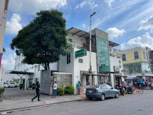 een vrouw die in een straat voor een gebouw loopt bij Hotel Santo Domingo Express in Villahermosa