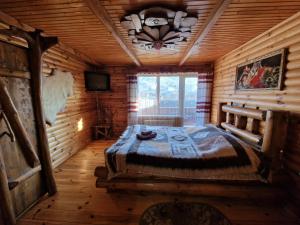 ein Schlafzimmer mit einem Bett in einem Blockhaus in der Unterkunft Гуцульська хата in Jaremtsche