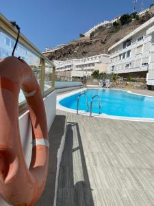 ein Schwimmbad mit einem Rettungsschwimmer neben einem Gebäude in der Unterkunft Peace and View Apartment Puerto Rico in Puerto Rico de Gran Canaria