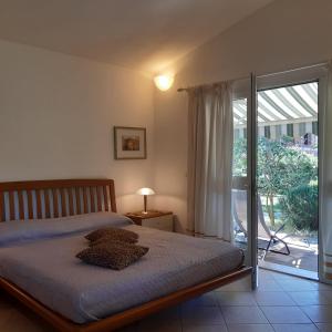 um quarto com uma cama e uma porta de vidro deslizante em casaisoladelba em Lacona