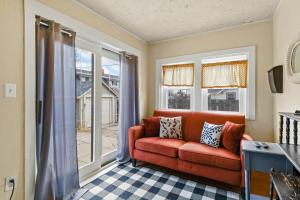 sala de estar con sofá rojo y ventanas en Spacious City House en Colorado Springs
