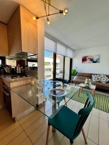 a kitchen with a glass table and chairs in a room at Lindo y equipado depto de 1d/1b en Metro Manquehue in Santiago