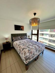 a bedroom with a bed and a large window at Lindo y equipado depto de 1d/1b en Metro Manquehue in Santiago