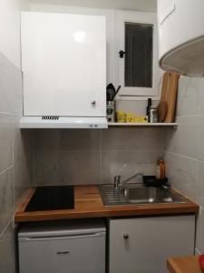 a kitchen with a sink and a white cabinet at Charmant studio cosy in Orléans +5 photos