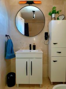 a bathroom with a white sink and a mirror at 'Casa Ideal' A22 - Las Arenas Complex in Caleta De Fuste