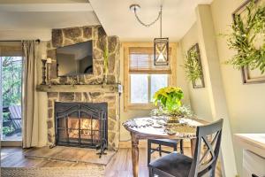 a living room with a table and a fireplace at Updated Banner Elk Condo, 2 Mi to Skiing! in Banner Elk