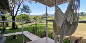 a view from the porch of a house with a hammock at The Dreamcatcher Bus in Sarchí
