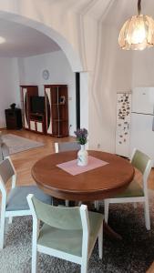 stół jadalny z krzesłami i wazonem kwiatów na nim w obiekcie City Park Apartments w Prisztinie
