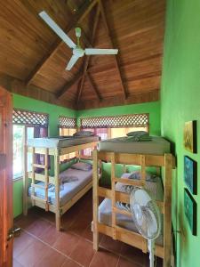 a room with two bunk beds and a ceiling fan at Casa Terra in Sámara