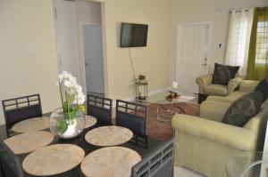 - un salon avec des canapés et une table fleurie dans l'établissement Jamaica Tranquility, à Lucea