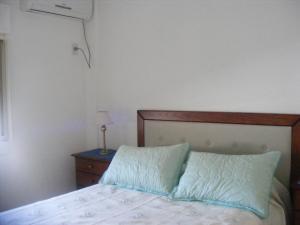 1 dormitorio con 1 cama con cabecero de madera y mesa en Departamento en Recoleta Santafesina en Santa Fe