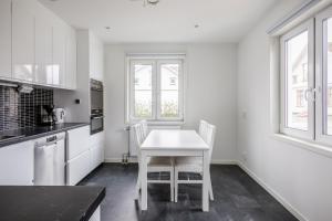 a white kitchen with a white table and chairs at New Flores in Huskvarna