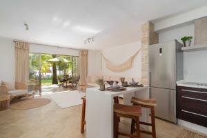 a kitchen and living room with a refrigerator and a table at CHAC at Chac Hal Al Puerto Aventuras in Puerto Aventuras
