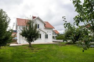 uma casa branca com um telhado vermelho em New Flores em Huskvarna