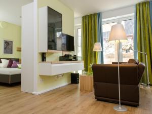 a living room with a couch and a television at de Luxe Suite Sonnenaue in Norderney