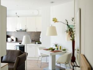 諾德奈的住宿－de Luxe Suite Sonnenaue，白色的厨房配有白色的桌子和椅子