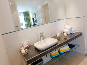 a bathroom with a sink and a mirror at de Luxe Suite Sonnenaue in Norderney