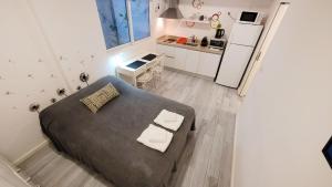 a small bedroom with a bed and a kitchen at Cozy studio - Palermo Chico in Buenos Aires