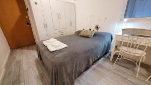 a small bedroom with a bed and a chair at Cozy studio - Palermo Chico in Buenos Aires