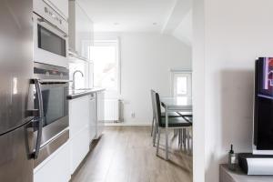 a kitchen and dining room with a table and a television at Flores 3 in Jönköping