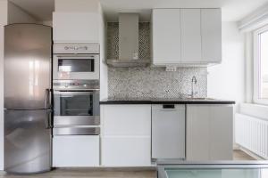 uma cozinha com armários brancos e um frigorífico de aço inoxidável em Flores 3 em Jönköping